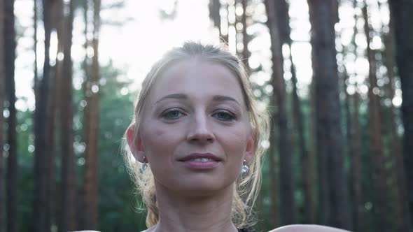 Young Fit Woman Making Namaste Gesture in Lotus Pose Closing Eyes at Forest