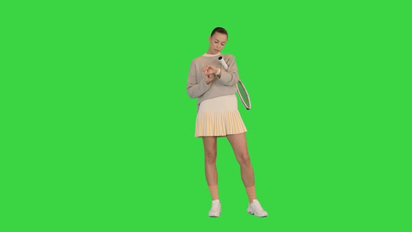 Beautiful Female Tennis Player Looking on Fitness Tracker on a Green Screen Chroma Key alt