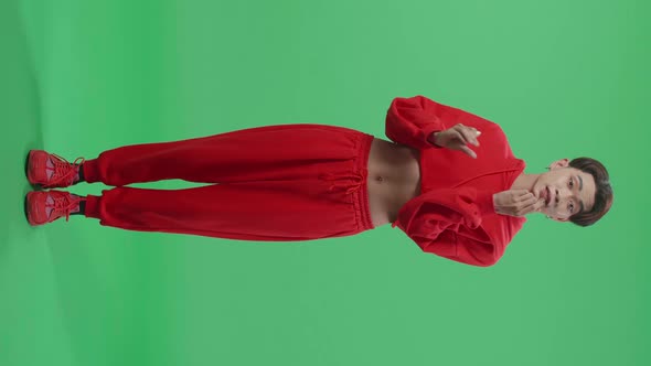 Full Body Of Asian Transgender Guy Applying Lipstick In The Green Screen Studio alt