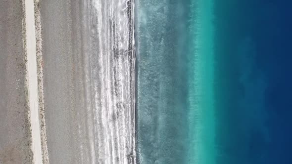 Gradient Blue Water of the Sea and White Gray Sandy Shore Aerial Photography From a Quadcopter