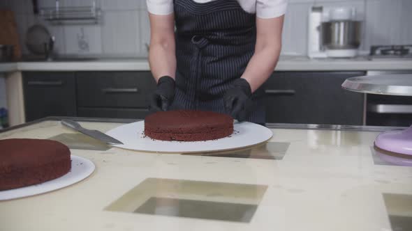 Confectionery  a Woman Cuts a Chocolate Sponge Cake Into Two Parts Using a String alt
