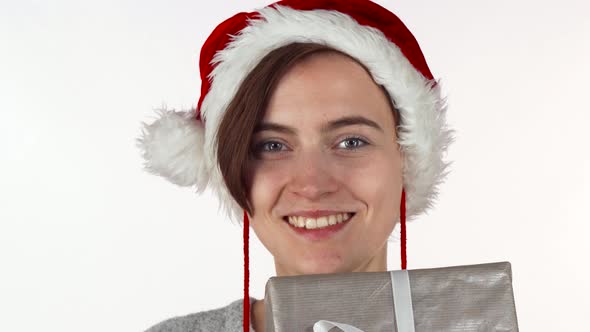 Attractive Christmas Woman Hiding Her Face Behind a Present Box alt