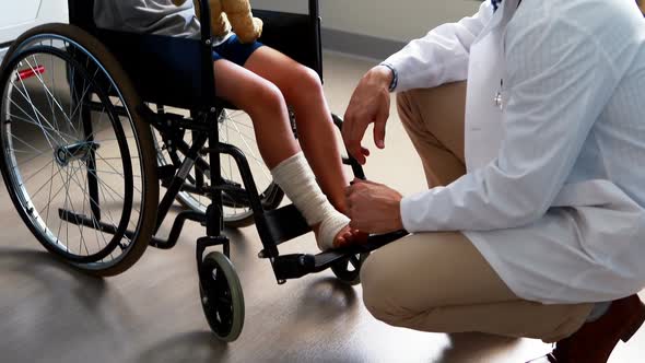 Male doctor interacting with child patient in ward alt