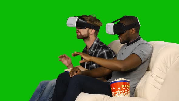 Men in VR Masks Watching a Movie with Popcorn. Green Screen alt