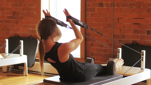 Woman exercising on gym equipment alt