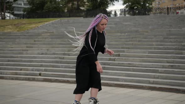 Video of a Girl in a Long Dress and with Bright Hair Skating Around the City