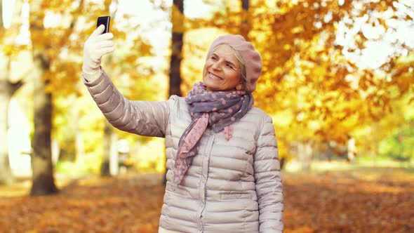 Senior Woman Taking Selfie at Autumn Park 10 alt