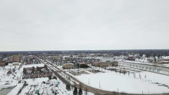 Cityscape aerial view including water, park, walking paths, homes and boats in dry dock.