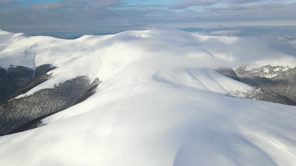 Amazing Aerial Flight Over Misty Mountain Range Meadows and Snow Covered Peaks in Winter Time alt