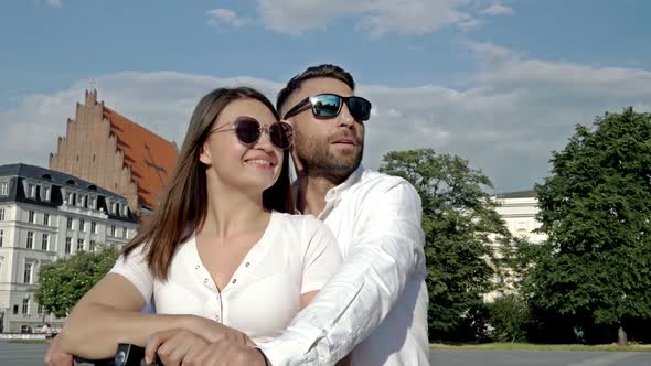 Summer Portrait of a Couple in Love on an Electric Scooter alt