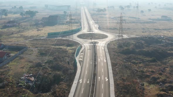 New empty four-lane road through desolate rural countryside, with clear surface marking of lanes alt