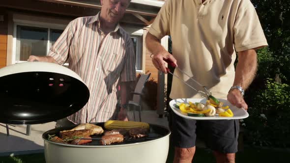 Senior Men Cooking on Barbecue Grill alt