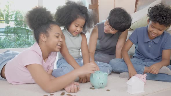 Happiness African family with mother and children saving money in piggy bank for planning future. alt