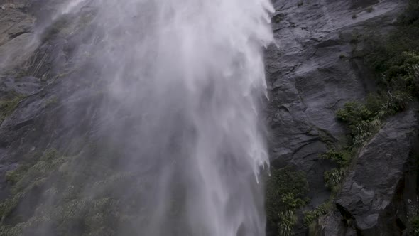Slow motion shot from underneath a waterfall from the back of a boat. Milford Sound, New Zealand. alt