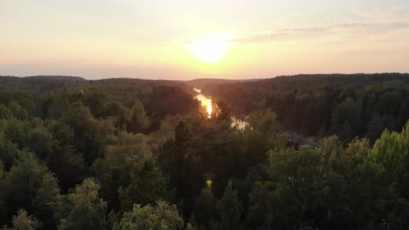 Fly low over trees on rocky hills of Ladoga skerries, beautiful sunset time alt