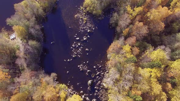 Beautiful drone overflight video of a river in the wilderness with three boat on land waiting to go alt