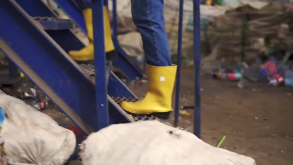 Tracking Footage of a Girl in Protective Working Clothes Eyeglasses Rubber Boots and Mask Going alt