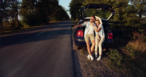 Couple Sitting in Car Trunk on Sunset