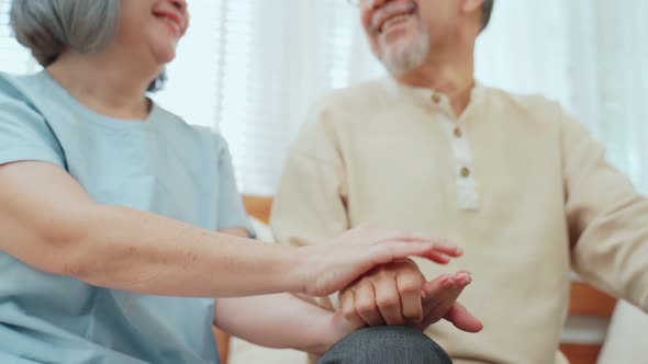 Elderly Grandmother hold older Grandfather's hand with gentle and comfort in living room at house. alt