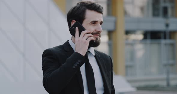 Charismatic Man in a Suit Speaks on His Phone in alt