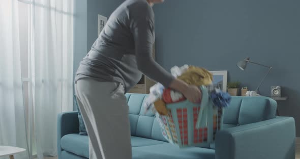 Pregnant woman doing laundry and resting on the sofa