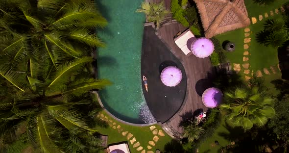 The view from the height of a young and beautiful woman is lying on the swimming pool and sunning. alt