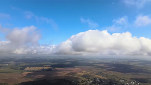 Aerial View From Airplane Window at High Altitude of Earth Covered with White Puffy Cumulus Clouds alt