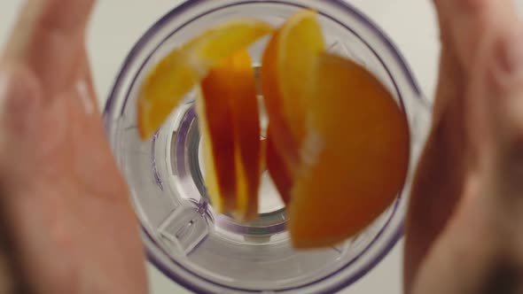 Slices of orange fall into mixer