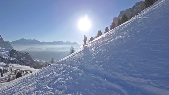 Slow motion shot of man snowshoeing in the dolomites at sunrise alt