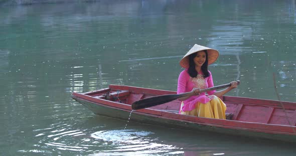 Vietnamese Woman Rowing A Boat alt
