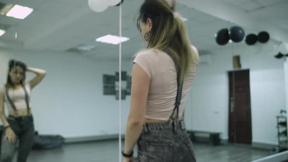 Caucasian female dancer choreographer performing a freestyle dance in dance studio against mirror wa alt