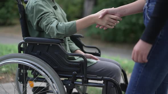 Side View Unrecognizable Disabled Caucasian Girl Greeting Friend Shaking Hands in Slow Motion alt