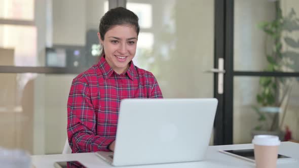 Indian Woman Celebrating While Using Laptop on Bench alt
