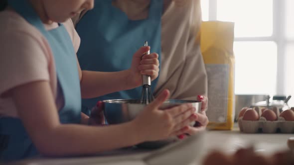 Calm Family Weekend in Home Mom and Daughter are Cooking Together Little Girl is Whipping Cream alt