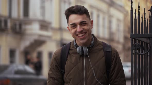Portrait of Pleased Joyful Student Guy 20s Wearing Backpack Laughing and Chuckling While Strolling alt