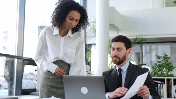 Two Successful Business Partners of Different Nationalities Working Together on an Important Project alt