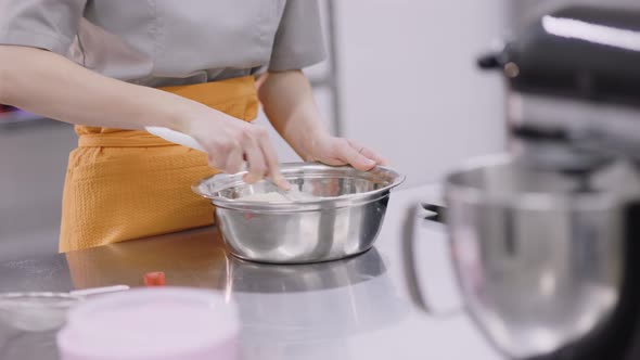 A Bright Girl Cooks Sweet Dishes at a Small Production Facility