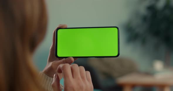 Woman Scrolling with Finger on Green Screen of Mobile alt