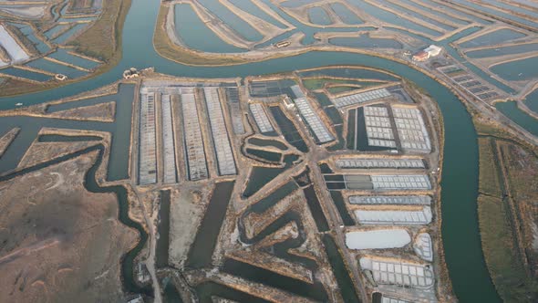 Aerial orbiting shot of natural salt pan, sea water flow through guadiana river, Castro Marim. alt