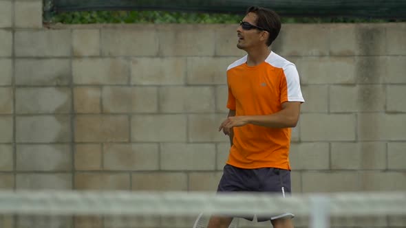 Two men playing outdoor tennis together. alt