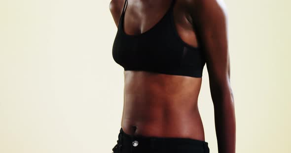 Androgynous person in sportswear posing against white background alt