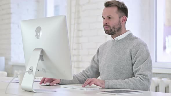 Pensive Creative Man Thinking and Working on Desktop alt