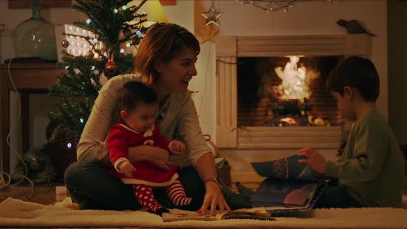 Mother reading Christmas book to children alt