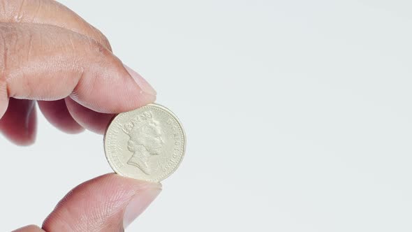 Fingers Hold A Uk Pound Coin Front