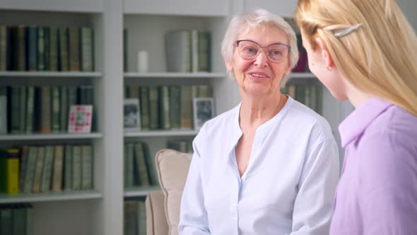 An elderly woman is surprised at the gift of her daughter alt