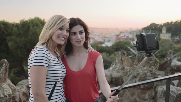 Young adult women taking picture on mobile phone in Barcelona