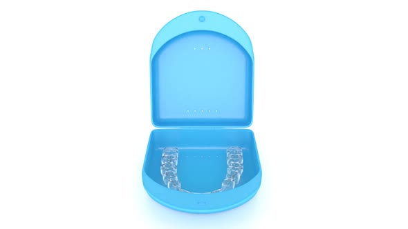 Lower, clear and removable aligner retainer in box case over white background