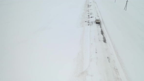 Truck rides on a snow-covered road top view