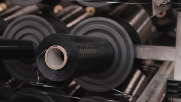 bobbin with black thread is spinning on the machine close-up