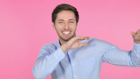 Happy Young Man Dancing on Pink Background alt